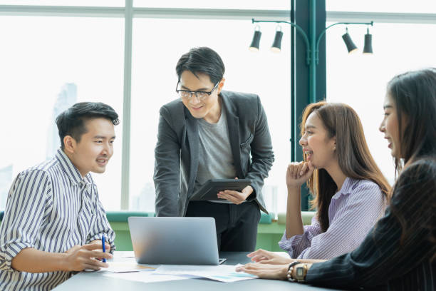 istock young asian man teaching students. man in grey cloth using laptop with friends. group of students studying, learning, tutoring in library 1463398607