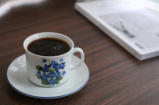 A cup of coffee with a book on a table