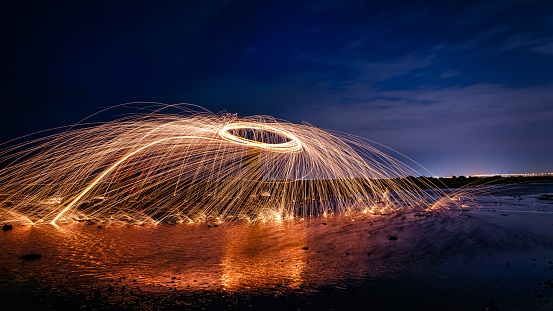 A bar of beautiful vibrant gold and circular wire wool in a long exposure at night in Kuwait