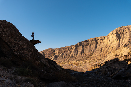 A young woman climbing along the desert of Tabernas in Almeria province in Andalusia