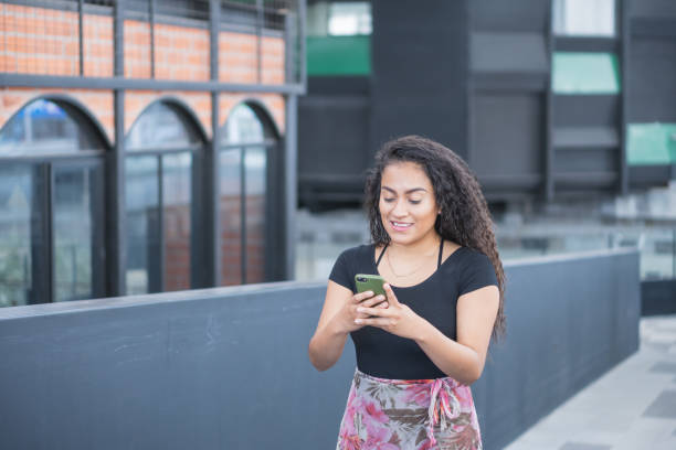 istock Happy Hispanic young female texting by her phone 1463400809
