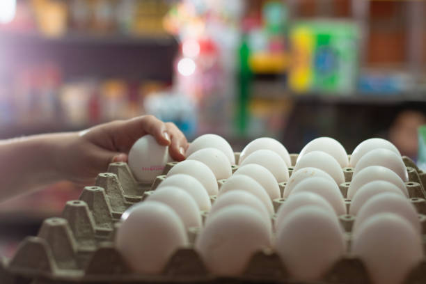 istock Closeup shot of a person taking a white egg from a box 1463403121