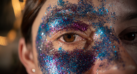 A close-up shot of a Hispanic girl with confetti make up