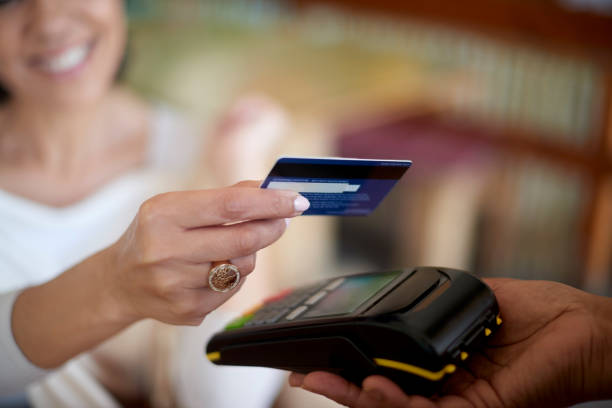 Credit card, hands or payment on a money machine by a happy customer via digital technology in a cafe. Finance, security or happy person shopping, buying or paying cash bill at store or coffee shop stock photo
