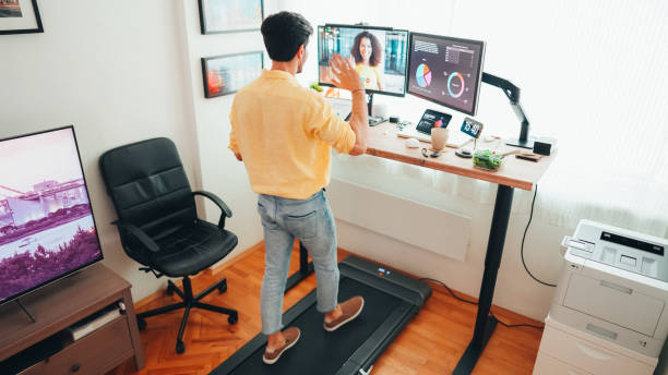 istock Man at standing desk home office talking on business video call 1463408559