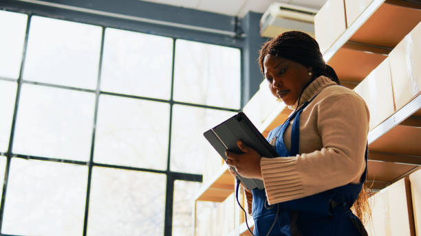 istock Woman working with scanner and tablet in storage room 1463409007