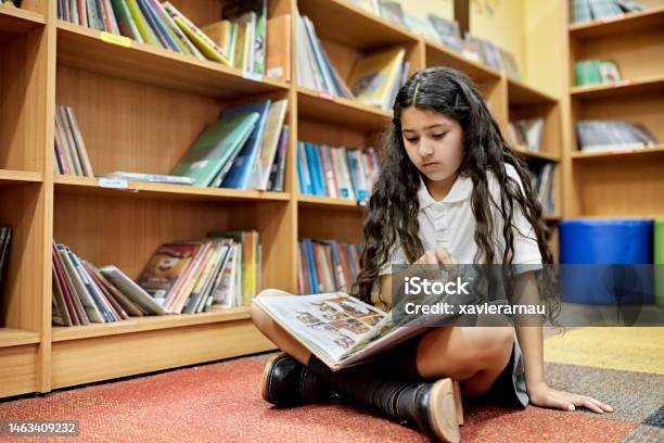 Young Hispanic Student Reading Graphic Novel Stock Photo - Download Image Now - Comic Book, Reading, Child