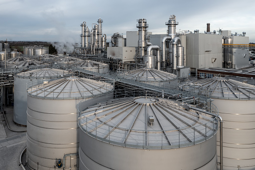 Aerial view above rows of chemical storage tanks and oil and fuel silos at an industrial site