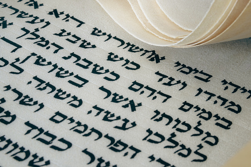 Open Megillat Esther [hebrew: Megillah, Megilah, Megila, Megilat, Megilla; russian: Мегила, Мегилла] (Book of Esther) isolated scroll on black backround. Read on the Jewish holiday of Purim.
