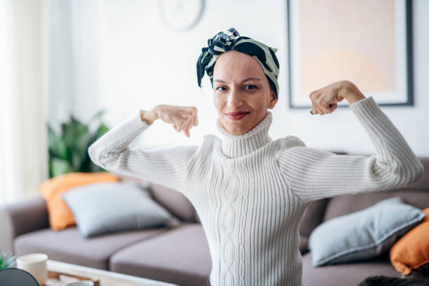 istock Strong cancer fighter flexing muscles and smiling. 1463413440