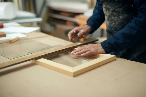 istock Carpenter hands, picture frame and design with glass for artwork with measurement, vision and ideas. Wood designer, engineer and artist in workshop, factory and workspace for manufacturing process 1463413700