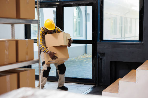 istock Delivery service african american loader carrying heave cardboard boxes 1463414935