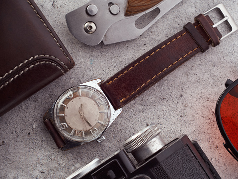 Classic vintage wristwatch with brown leather strap and group of objects. Hipster items