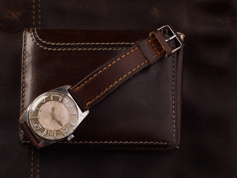 Classic vintage wristwatch with brown leather strap and a wallet