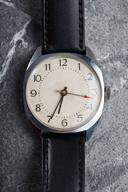 istock Classic vintage wristwatch with black leather strap on gray stone background 1463415834
