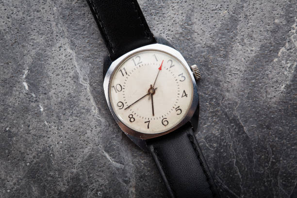 istock Classic vintage wristwatch with black leather strap on gray stone background 1463416603