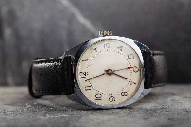 istock Classic vintage wristwatch with black leather strap on gray stone background 1463416629
