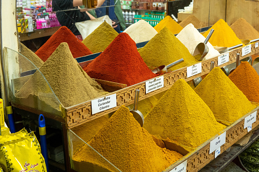 Spices traditionally displayed in cone shape in the Medina (ancient, historic shopping center) in Marrakech, Morocco. It is evening: electric lights illuminate the spices