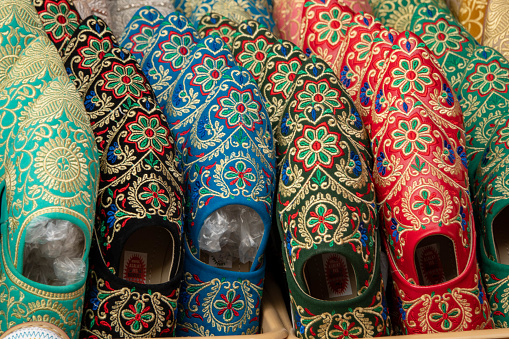 Close-up of colorful Arabian mules (slippers) displayed in a market stall. The photo was taken in the medina (an ancient, historic market) in Marrakech, Morocco