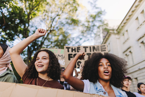 Generation Z taking action against climate change. Group of youth activists protesting against global warming and pollution. Multicultural young people joining the global climate strike.