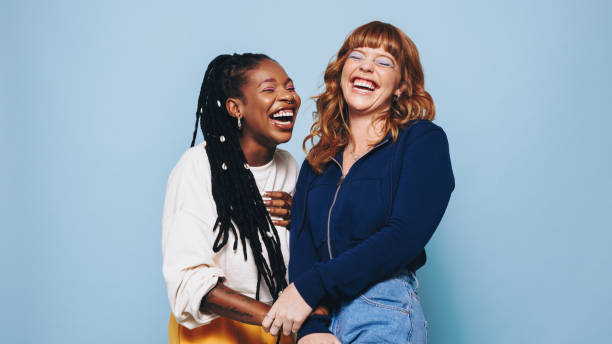 istock Funny best friends laughing cheerfully while standing together in a studio 1463422770