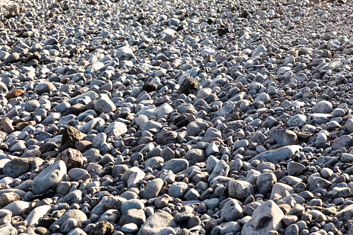 background of round beach with cobble stones washed out by the ocean
