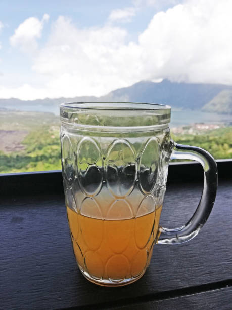 Orange juice on the glass, placed on the table with mountain background
