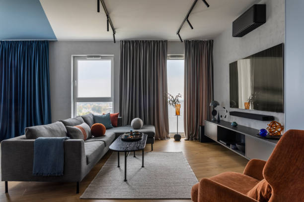 istock Modern living room interior with gray sofa, black coffee table, orange armchair 1463434877