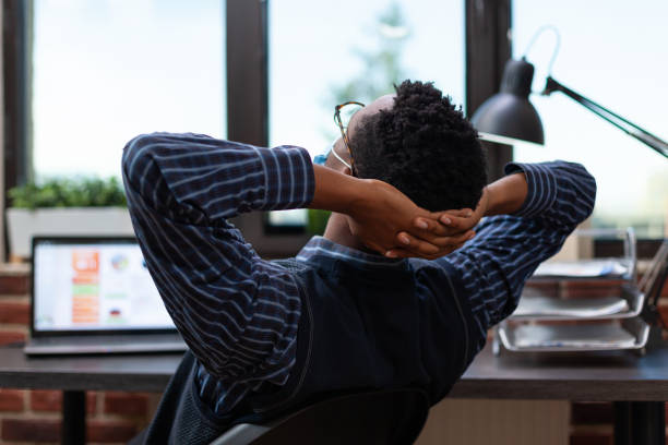 istock Overworked employee wearing covid protection mask taking a nap at work 1463437742
