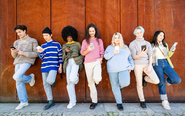 istock Young people looking down at cellular phone, teenagers leaning on a wall and texting with their smartphones, concepts about social issues, global communication, internet addiction 1463441097