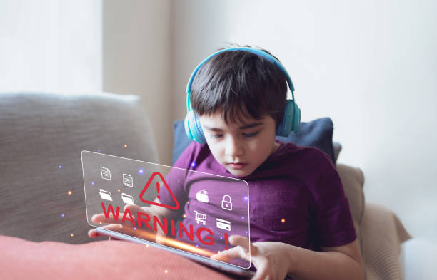 istock School kid doing homework on tablet and receiving warning triangle sign for error notification display cyber attack,Danger Caution Warning Concept for Protecting Kid while using internet 1463442835