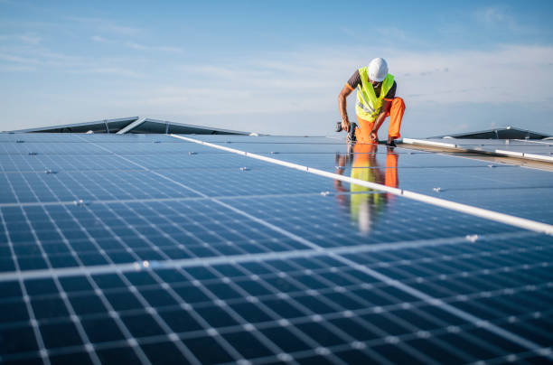 istock Man with drill screwdriver installs panels at a solar power plant. 1463443588