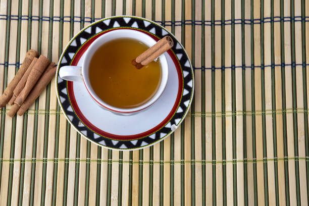 a cup of cinnamon tea and cinnamon sticks. overhead shot
