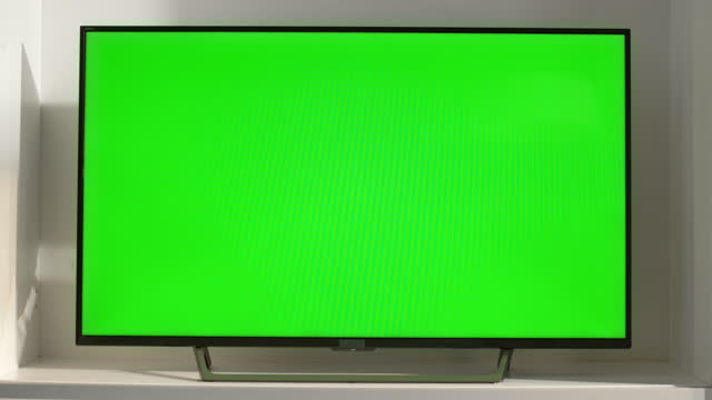 Chroma key smart TV in living room closeup. Device with blank screen in sunlight
