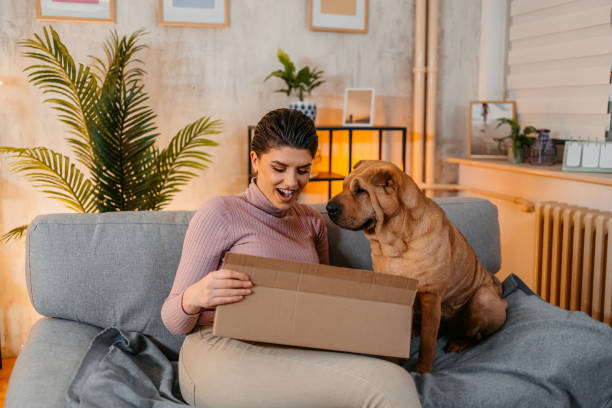 istock Young Woman With Her Dog Unpacking A Package She Ordered Online 1463449947