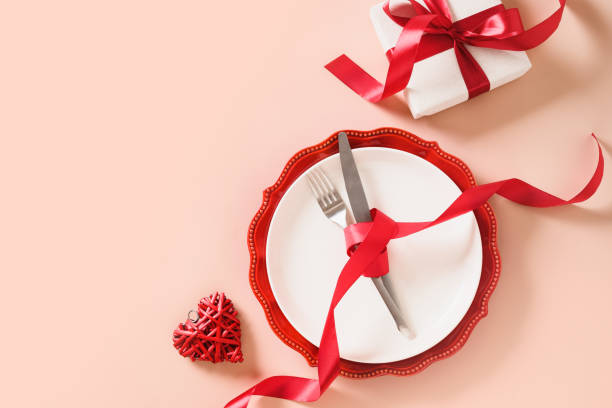 istock Valentines day table place setting with red rose, two hearts on pink background. View from above. Greeting card. Invitation to romantic dinner. 1463453145