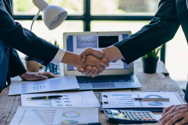 istock Successful negotiation and handshake concept Two businessmen shake hands with partners to celebrate cooperation and teamwork, mergers and acquisitions. Successful negotiations, business deal concept 1463456852