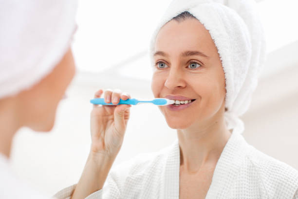istock Happy Lady Brushing Teeth With Toothbrush Standing In Bathroom Indoor 1463457306