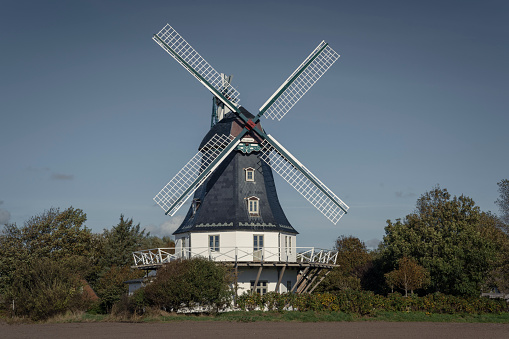 Borgsum, Germany - October 09, 2022: The Borgsumer Muehle is a so-called Erdhollaender on the North Frisian island of Foehr. Taken with a bright blue sky in autumn.