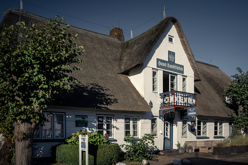 Nieblum, Germany - October 09, 2022: The Haus Landfrieden is a thatched house on the North Frisian island of Foehr. Taken under a bright blue sky in autumn.