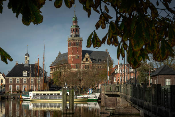 Leer, Germany - October 27, 2022: The skyline of the old town of Leer, city in East Frisia, Lower Saxony. With ships on the Leda river, town hall and bridge on a splendid day in autumn.