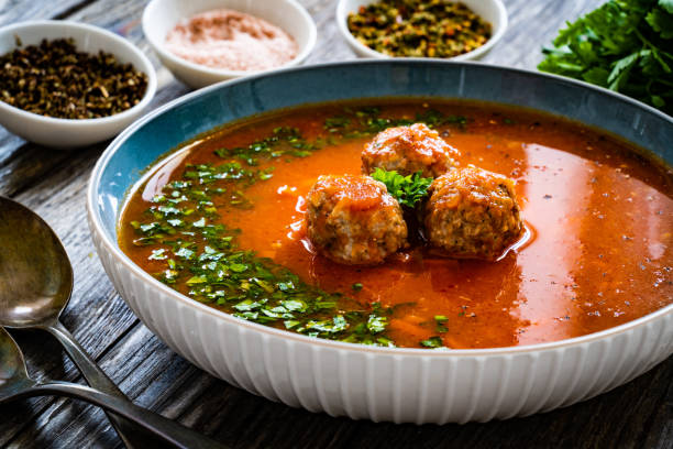 Tomato soup with meatballs on wooden table
