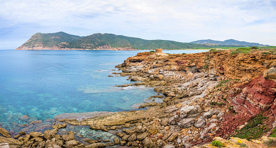 Colorful rocks introduce to the deep bay of Porto Ferro, a remote angle in the northwest of Sardinia (6 shots stitched)
