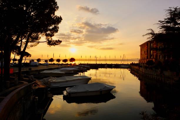 The city of Sirmione in northern Italy at sunset. Sunset in the city of Sirmione. The setting sun makes its way into the narrow streets of Sirmione on the shores of Lake Garda. sirmione es un municipio situado en el territorio de la provincia de brescia, (italia). limita con lombardía y peschiera del garda en la provincia de verona y la región del véneto. tiene un centro histórico que se encuentra en la parte inferior del lag