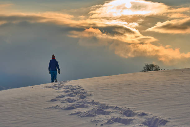 istock woman winter hiking in deep snow during sunset 1463463334