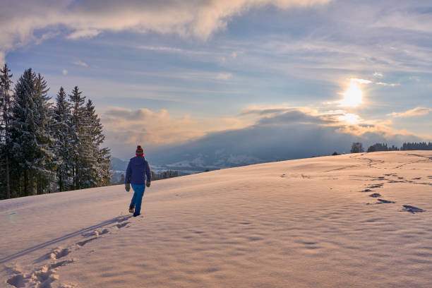 istock woman winter hiking in deep snow during sunset 1463464482