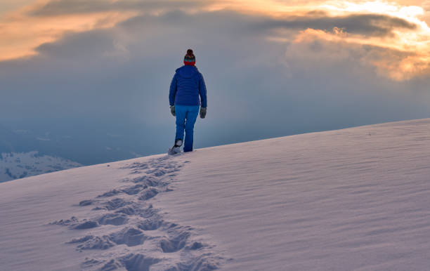 istock woman winter hiking in deep snow during sunset 1463464499