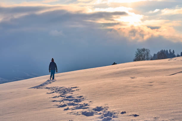 istock woman winter hiking in deep snow during sunset 1463464878