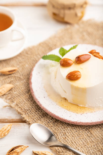 istock Ricotta cheese with honey and almonds on white wooden. side view, selective focus. 1463465727