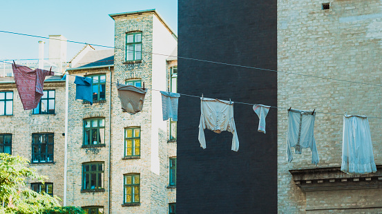 laundry drying on a line with a tenement house in the background